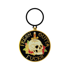 Wood Rocket Fresh Outta Fucks enamel keychain with gold-rimmed skull and dagger design on black