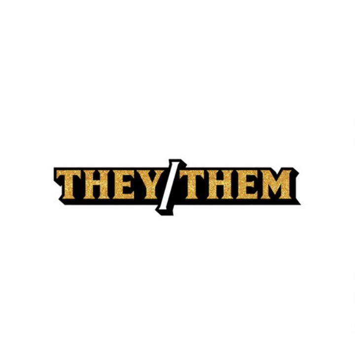 Wood Rocket They/Them enamel pin with gold glitter lettering on a black base