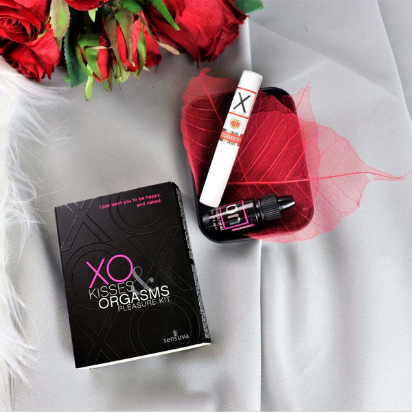 XO Kisses and Orgasms Pleasure Kit box beside arousal oil and lip balm with red roses