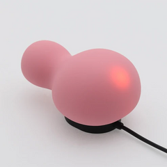 YUKI Nadeshiko on magnetic charging cradle with red indicator light glowing through silicone